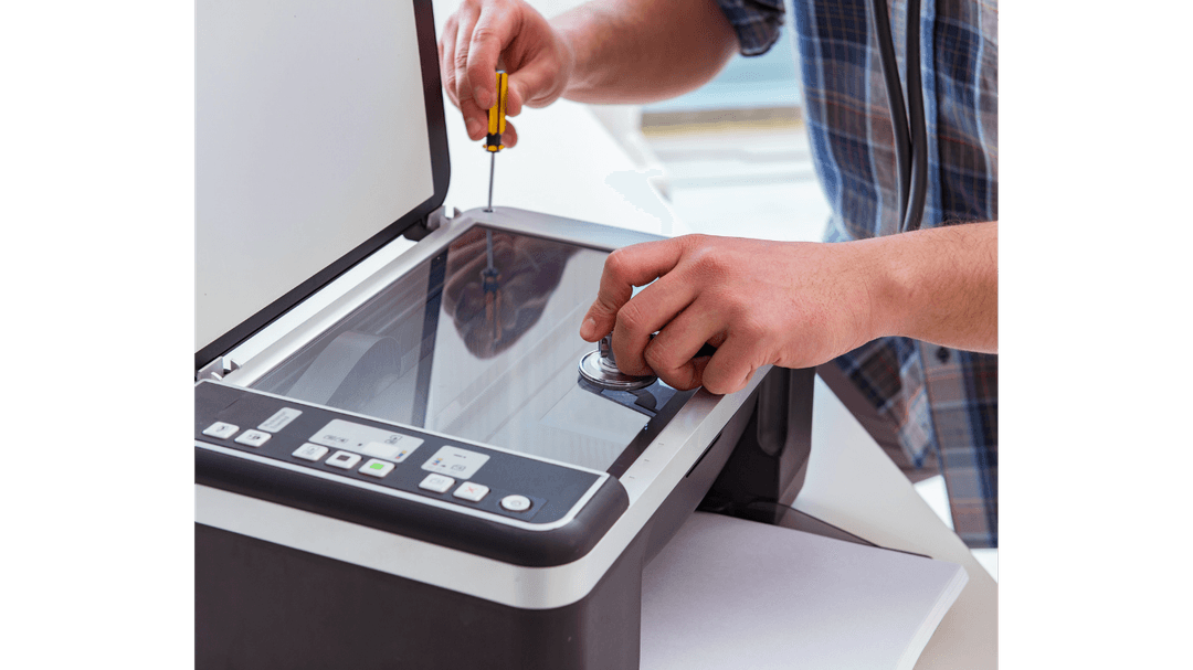 Mãos reparando uma impressora